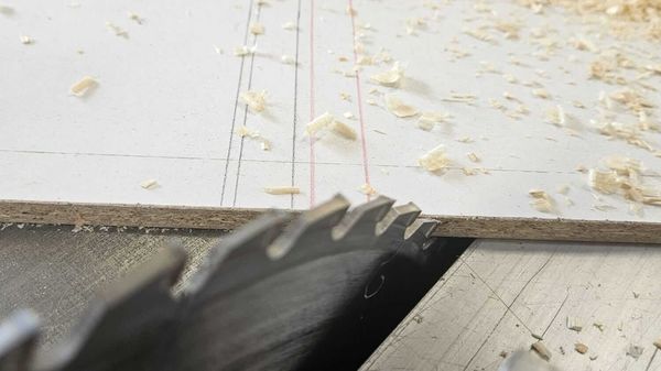 Nahaufnahme eines Kreissägeblattes beim Zerschneiden einer Holzplatte